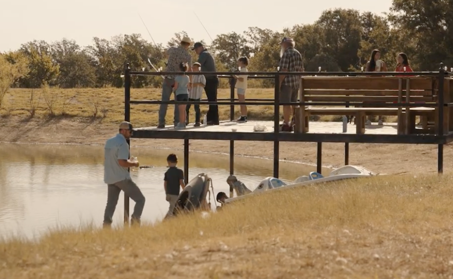 Families fishing together off the pond dock