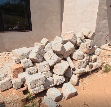 Stacked structural blocks staged outside a home under construction