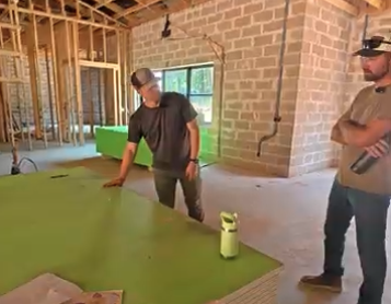 Chase walking through a framed home interior with a partner from Hiwassee Healthy Homes